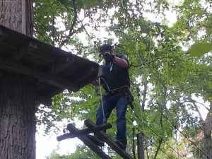 A congregation member climbing across a rope ladder.